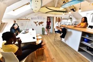 a group of women sitting at a table in a tiny house at SURF HOSTEL BIARRITZ in Biarritz