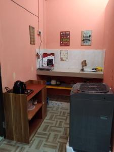 Habitación con cocina con fregadero y nevera. en Putat Gajah Villa PASIR MAS en Pasir Mas