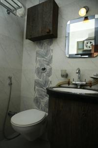 Shaleen Elegance Homestay Nakki Lake 400 meters في مونت ابو: حمام مع مرحاض ومغسلة ومرآة