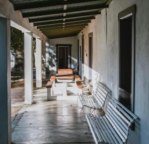 a row of benches sitting on a porch at Oregon House in Riebeek-Wes