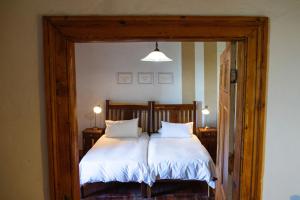 a bedroom with a bed with white sheets and pillows at Oregon House in Riebeek-Wes