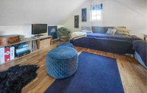 sala de estar con sofá azul y reposapiés azul en Amazing Home In Hssleholm With Wifi, en Hässleholm