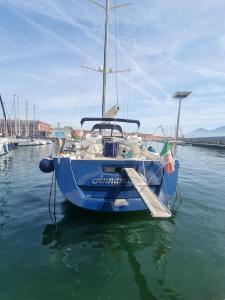 a blue boat is docked in the water at Barca a vela PROCIDA in Naples