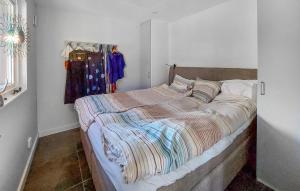 2 Bedroom Cozy Home In Hssleholm في هسلهولم: غرفة نوم بسرير مع لحاف مخطط