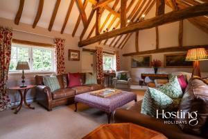 a living room with leather couches and a table at Bullocks Farm House - 6 Exceptional Bedrooms in High Wycombe