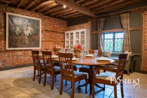 a dining room with a wooden table and chairs at Bullocks Farm House - 6 Exceptional Bedrooms in High Wycombe
