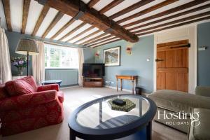 a living room with a couch and a glass table at Bullocks Farm House - 6 Exceptional Bedrooms in High Wycombe