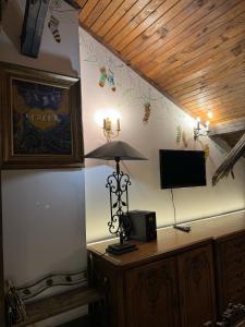 Zimmer mit einer Lampe und einem TV an der Wand in der Unterkunft Mini Hotel-Bohemi in Plowdiw