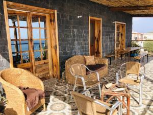 un porche cubierto con sillas y un sofá en Get house kira, en Cidade Velha