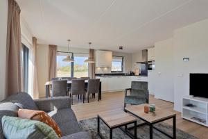 a living room with a couch and a table at Vakantiepark Wulpdal in Scherpenisse