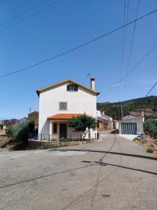 een klein wit huis aan de kant van een weg bij Casa da Esteva - Vila de Rei in Vila de Rei