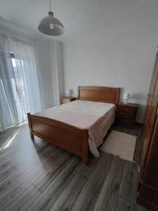 1 dormitorio con 1 cama y suelo de madera en Casa da Esteva - Vila de Rei, en Vila de Rei