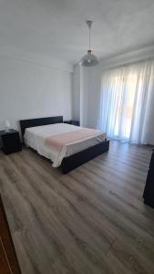 een slaapkamer met een bed en een houten vloer bij Casa da Esteva - Vila de Rei in Vila de Rei