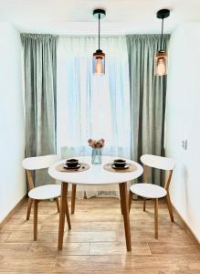 a dining room table with two chairs and a white table at Cozy Spot in Deva