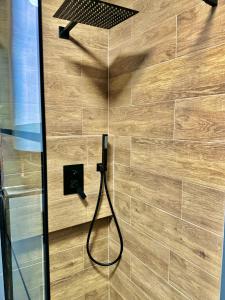 a shower with a hose attached to a wooden wall at Cozy Spot in Deva