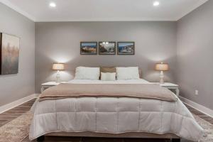 a bedroom with a large bed with two lamps at *Chic Beach Cottage Retreat* near Beach/downtown in Gulfport