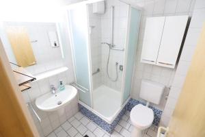 uma casa de banho com um chuveiro, um lavatório e um WC. em Horizont-Wohnung-3 em Cuxhaven
