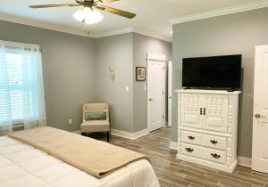 a bedroom with a flat screen tv and a bed at *Chic Beach Cottage Retreat* near Beach/downtown in Gulfport