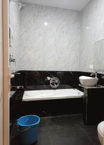 y baño con bañera y lavamanos. en R Hotels By Suraj Residency Yercaud en Yercaud