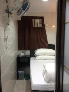 Habitación pequeña con cama y ventana en Payless Guest House A2, en Hong Kong