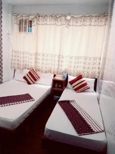 2 camas con almohadas rojas y blancas en una habitación en Payless Guest House A2, en Hong Kong