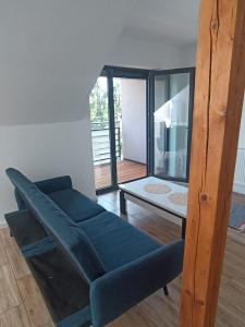 a living room with a blue couch and a table at Apartament Aleja Lipowa in Górki Wielkie
