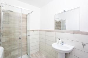 a white bathroom with a sink and a shower at Tourist Apartment anna in Bracciano