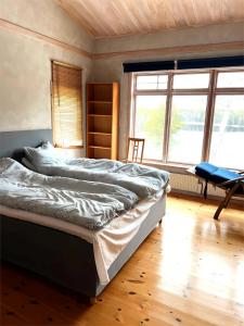 ein Schlafzimmer mit einem Bett, einem Stuhl und einem Fenster in der Unterkunft Värmdö in Värmdö