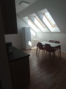 a kitchen with a table and chairs in a room with skylights at Apartament Aleja Lipowa in Górki Wielkie