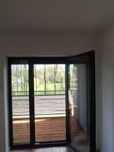 a sliding glass door in a room with a balcony at Apartament Aleja Lipowa in Górki Wielkie