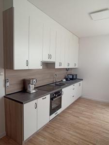 a kitchen with white cabinets and a counter top at Apartament Aleja Lipowa in Górki Wielkie