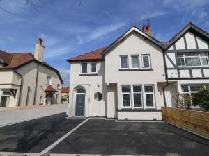 a white house with a parking lot at Park View in Llandudno