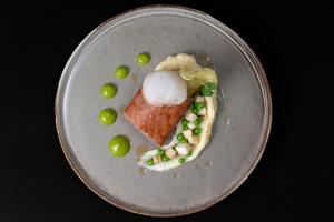 a plate of food with peas and a piece of cake at Nira Alpina in Silvaplana