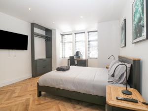 a bedroom with a bed and a desk and a tv at Park View in Llandudno
