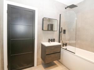 a bathroom with a sink and a shower and a mirror at Park View in Llandudno +26 photos