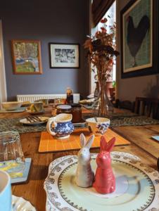 two ceramic rabbits sitting on a plate on a table at Number 18 in Whitby