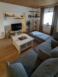 a living room with two couches and a tv at Ferienwohnung im Zenngrund in Neuhof an der Zenn