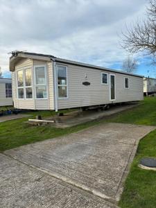 une petite maison assise sur le côté d'une allée dans l'établissement 2 bedroom caravan, sea views, parking, à Eastchurch