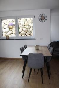 a table and chairs in a room with two windows at Ferienwohnung Alpenblick in Wessobrunn