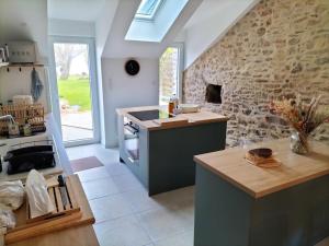 a kitchen with a stove and a stone wall at Coté Golfe - Golfe du Morbihan in Sarzeau