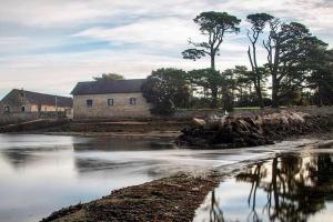 a stone building next to a body of water at Coté Golfe - Golfe du Morbihan in Sarzeau