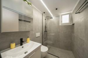 La salle de bains est pourvue d'un lavabo, de toilettes et d'une douche. dans l'établissement 'Santa Marina Detached Cozy House In Egaleo, à Athènes