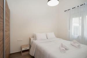 - une chambre avec un lit blanc et 2 serviettes dans l'établissement 'Santa Marina Detached Cozy House In Egaleo, à Athènes
