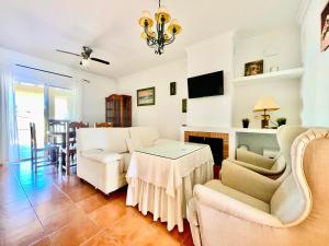 a living room with white furniture and a table at Casa Boga - Urbasur in Islantilla