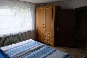 sypialnia z łóżkiem, komodą i oknem w obiekcie Petras Traum-Ferienwohnung mit Wiese und Terrasse w mieście Kandern