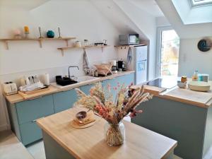 a kitchen with a vase of flowers on a table at Coté Golfe - Golfe du Morbihan in Sarzeau +43 photos