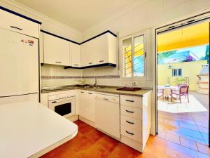 a kitchen with white cabinets and a white refrigerator at Casa Boga - Urbasur in Islantilla