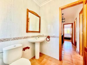 a bathroom with a sink and a toilet and a mirror at Casa Boga - Urbasur in Islantilla +12 photos