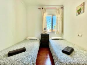two twin beds in a room with a window at Casa Boga - Urbasur in Islantilla