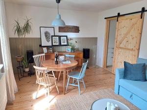Unique Cottage House in Gdańsk في غدانسك: غرفة معيشة مع طاولة وكراسي وأريكة زرقاء